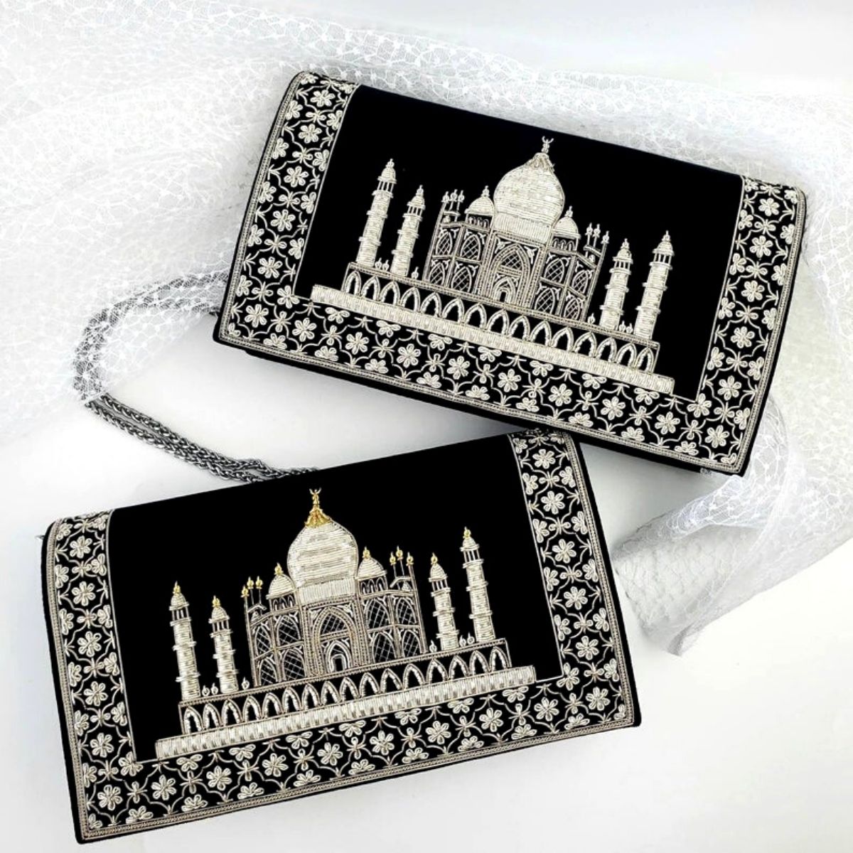 Two Taj Mahal handbags, one with gold accents, the other with silver accents.