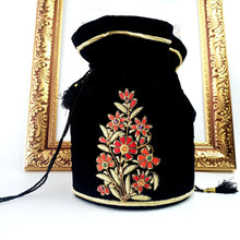 Load image into Gallery viewer, Black velvet potli bag embroidered with red and gold flowers, luxury bucket bag with zardozi embroidery.