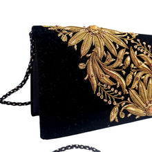 Load image into Gallery viewer, Side view of black velvet luxury evening clutch bag embroidered with two large flowers on the bias, in antique gold color and embellished with genuine gemstones, floral wedding clutch, black and antique gold zardozi purse.