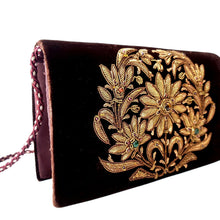 Load image into Gallery viewer, Side view of luxury chocolate brown velvet evening clutch bag embroidered with large central floral wreath in antique gold color and embellished with genuine gemstones, floral wedding clutch, black and gold zardozi purse.