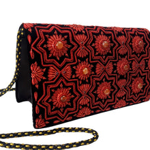 Load image into Gallery viewer, Side view of luxury black velvet evening clutch bag embroidered with geometric pattern of eight sided red stars and red flowers embellished with genuine gemstones, Christmas clutch, red and black zardozi purse.