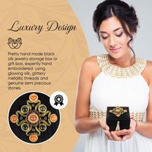 Load image into Gallery viewer, Model holding small square black silk keepsake box embroidered in gold with genuine gemstones.