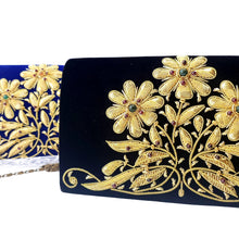 Load image into Gallery viewer, Side view of luxury black velvet evening clutch bag embroidered with three gold daisy flowers and embellished with genuine gemstones, floral wedding clutch, black and gold zardozi purse.