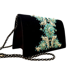 Load image into Gallery viewer, Side view of luxury black velvet evening clutch bag embroidered with turquoise colored central flower and radiating silver leaves and embellished with genuine turquoise gemstone, floral wedding clutch, black and silver and blue zardozi purse.
