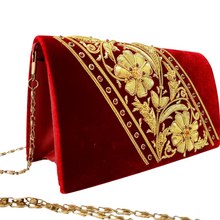 Load image into Gallery viewer, Side view of luxury burgundy velvet evening clutch bag embroidered with two large gold flowers on  the bias and embellished with gemstones, floral wedding clutch, red and gold zardozi purse.