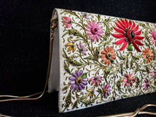 Load image into Gallery viewer, Ivory silk clutch bag embroidered with red and multicolor silk flowers with gold tone chain, zardozi evening bag, side view. 
