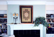 Load image into Gallery viewer, Statement large exclusive luxury hand embroidered silk floral tapestry with star rubies, framed zardozi jewel carpet wall art, hanging over fireplace in a room. 
