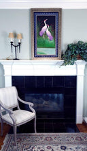 Load image into Gallery viewer, Embroidered bird silk wall art, two standing cranes with purple feathers embroidered on black velvet with an ornate border, framed, zardozi art, shown over a fireplace.