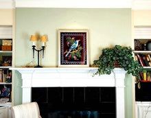 Load image into Gallery viewer, Embroidered bird wall art, large silk blue bird embroidered on black velvet with ornate border, framed, zardozi art, view in a room over a fireplace.