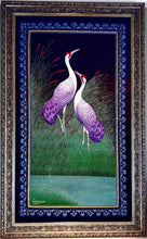 Load image into Gallery viewer, Embroidered bird wall art, two cranes with purple feathers standing in a grassy field embroidered on black velvet with an ornate border, framed, zardozi art.