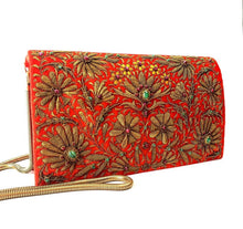 Load image into Gallery viewer, Orange velvet clutch bag embroidered with metallic copper flowers and embellished with star rubes, zardozi evening bag, gold tone strap, side view.