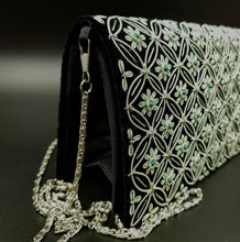 Load image into Gallery viewer, Embroidered black velvet evening bag with silver and green flowers and inlaid with gemstones, side view. 
