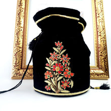Load image into Gallery viewer, Black velvet potli bag embroidered with red and gold flowers, luxury bucket bag with zardozi embroidery. 
