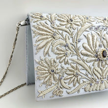 Load image into Gallery viewer, Luxury pale blue silk clutch hand embroidered with silver flowers and embellished with amethyst gemstone, side view. 
