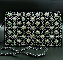Load image into Gallery viewer, Designer black velvet handbag embroidered with green flowers in quatrefoil pattern and inlaid with garnets. 
