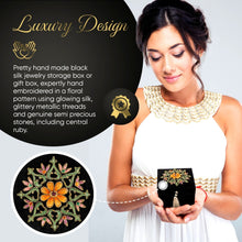 Load image into Gallery viewer, Model holding small black jewelry storage box embroidered with orange flower and ruby gemstone.
