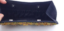 Load image into Gallery viewer, Black clutch embroidered with yellow flowers and embellished with rubies, zardozi handbag, interior view, showing full length gathered pockets. 
