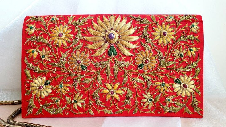 Gold and caramel colored silk flowers embroidered on vibrant red silk clutch embellished with star rubies, gold tone chain, zardozi purse.