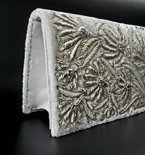 Load image into Gallery viewer, Bridal clutch in ivory velvet embroidered with silver lotus flowers and embellished with amethyst, zardozi evening bag, side view. 
