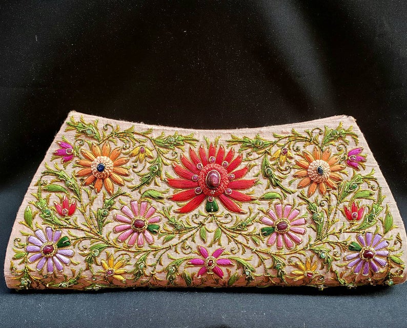 Peach silk clutch bag with multicolored silk flowers and central red lotus flower embellished with star rubies, zardozi purse