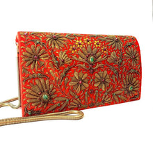 Load image into Gallery viewer, Orange velvet clutch bag embroidered with metallic copper flowers and embellished with star rubes, zardozi evening bag, gold tone strap, side view. 
