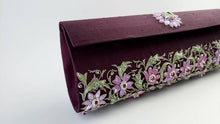 Load image into Gallery viewer, Maroon purple zardozi embroidered silk clutch bag with all over purple and pink floral design and embellished with emerald and star rubies, side view.
