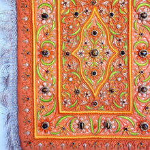 Load image into Gallery viewer, Embroidered jewel carpet wall hanging in orange floral pattern and tiger eye stones, embroidered orange silk flowers on orange velvet, zardozi tapestry, close up view. 
